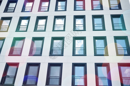 现代公寓楼在晴朗的一天与蓝天现代公寓楼的门面阳光图片