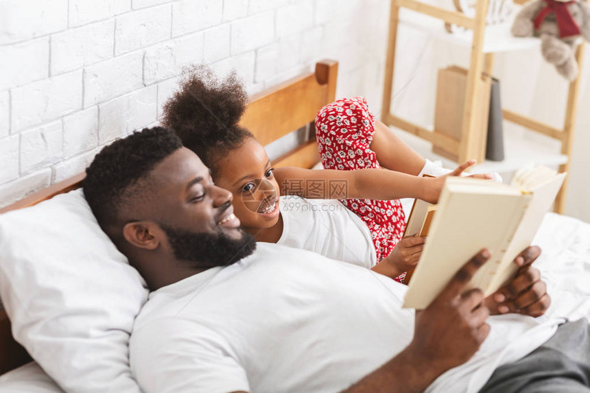 照顾非洲爸在卧室给女儿看书空闲的房图片