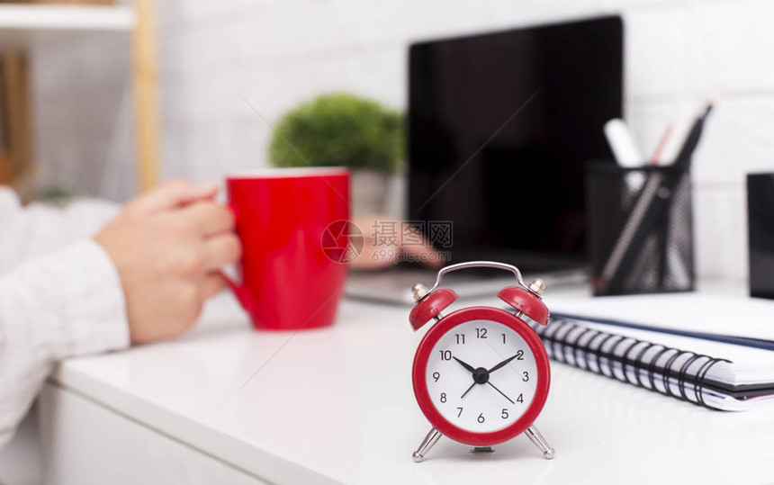 时间管理概念红色闹钟和上午咖啡杯放在办公室桌图片