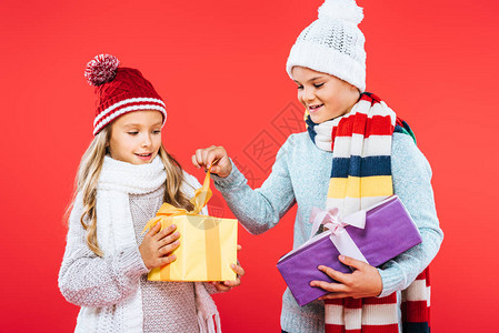 两个笑着的小孩穿着冬装拿着礼物图片