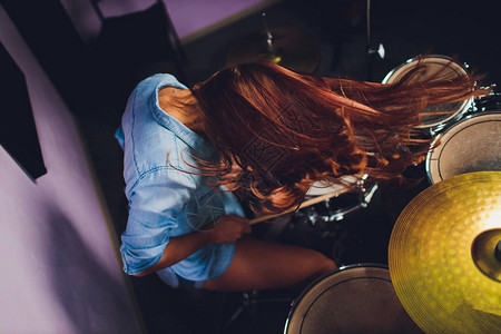 一名女鼓手在舞台上打鼓的图片