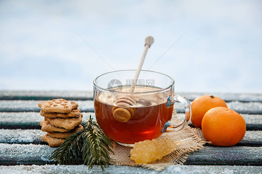 冬季森林里加蜂蜜橘子和饼干的热茶杯圣诞节死寂生命的概念Copy空图片