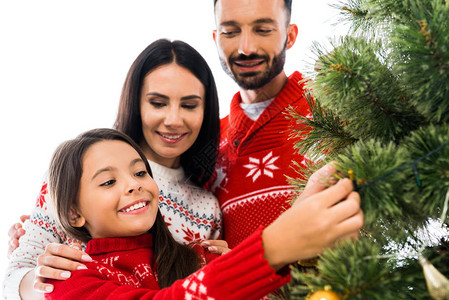 快乐的孩子装饰圣诞树在父母被孤立图片