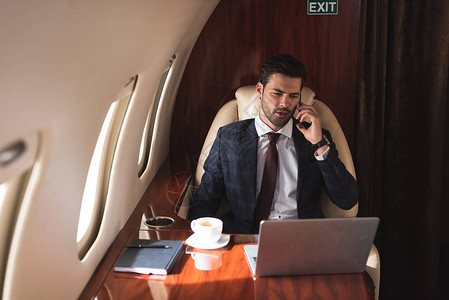 男领导人在商务旅行时用笔记本电脑在飞机图片