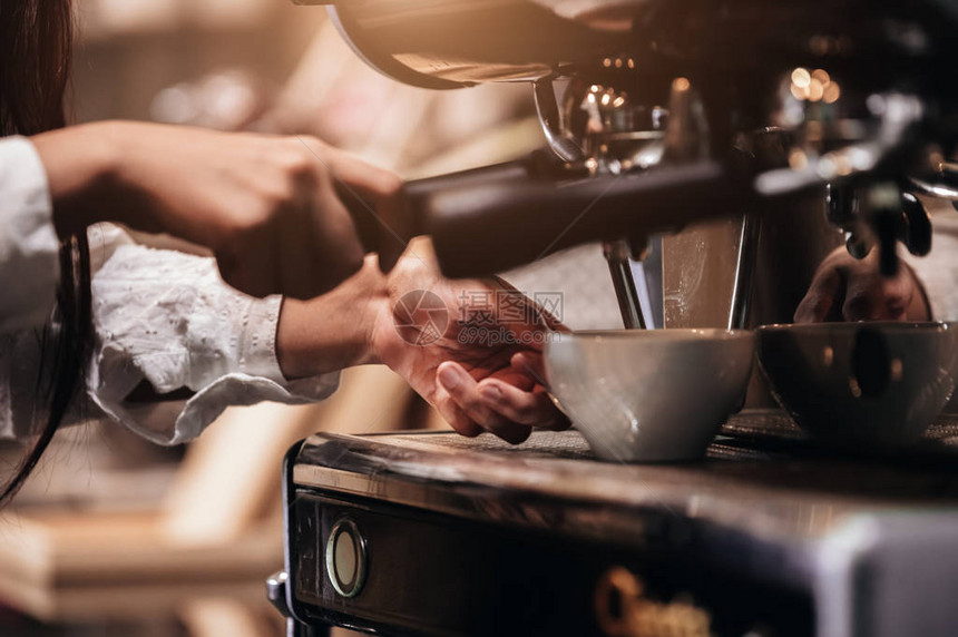 专业女咖啡师手在餐厅或咖啡店用咖啡机制作咖啡的特写镜头人和生活方式商业食品和饮料的概图片