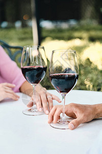 在户外餐厅浪漫约会时配着红酒杯的图片