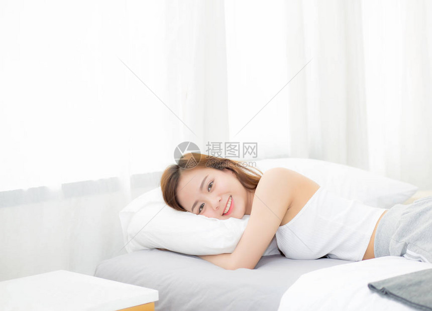 美丽的亚洲年轻女子的肖像睡在床上图片