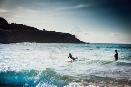 男孩在冲浪上骑着冲浪在海上冲浪图片