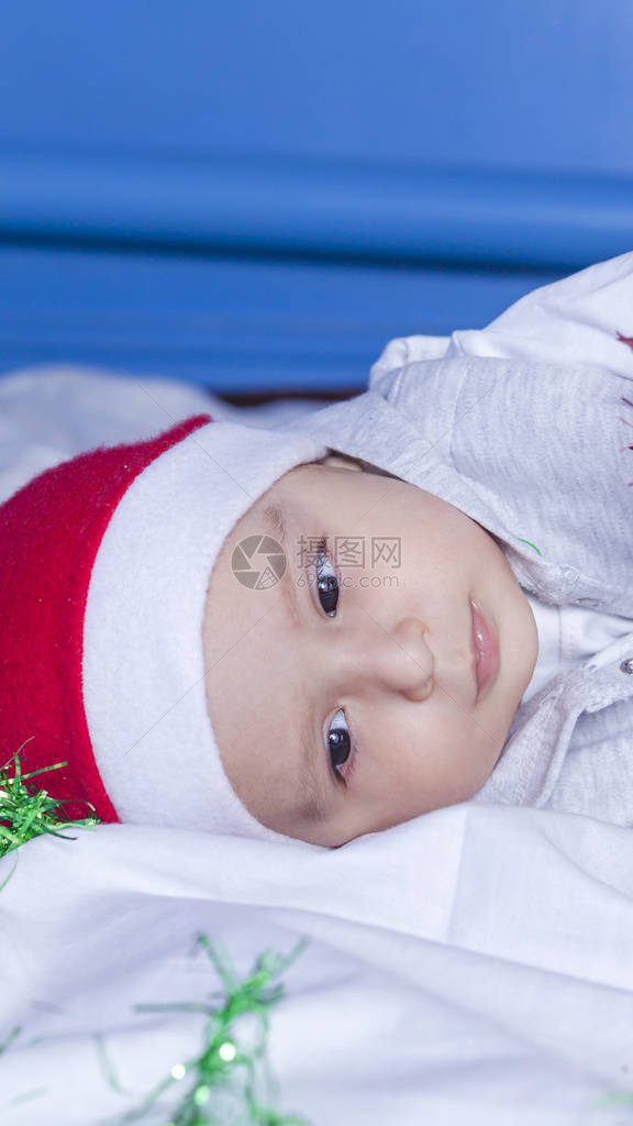 小圣诞老人男孩玩圣诞节或新年节日花环戴着圣诞老人帽的1岁男婴圣诞节的孩图片
