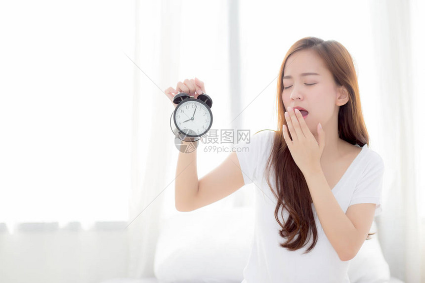 美丽的年轻亚洲女人在早上打哈欠醒来图片