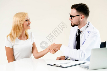 男医生在医院办公室与女病人握手医疗保图片