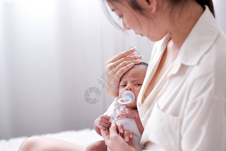 刚出生的婴儿被她的亚洲妈抱着图片