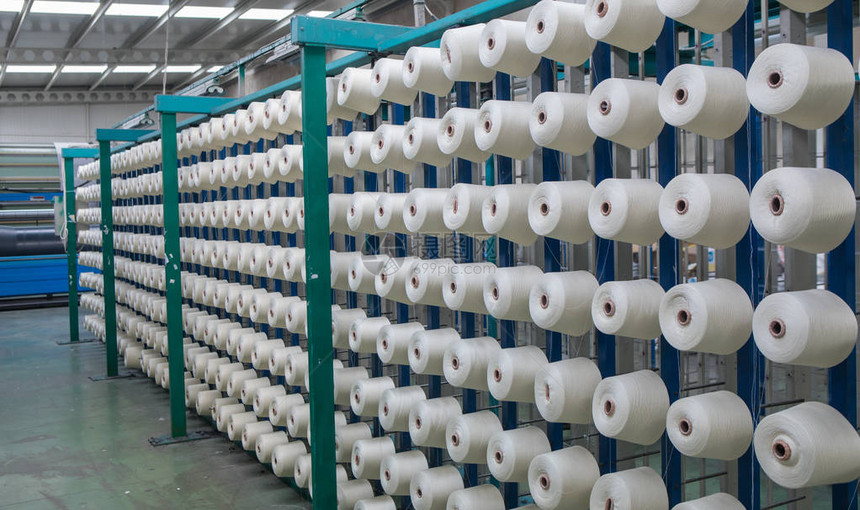 纺织厂整经机上的一组梭芯线锥在一家纺织厂制作纱球纺织工业纺织厂纺图片