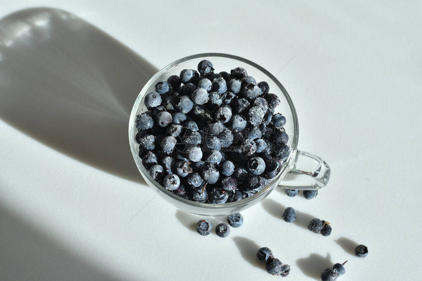 玻璃杯中的蓝莓关闭选择焦点和弗罗斯特新鲜蓝莓与白色背景上的水滴健康和节食饮的概念软选择焦图片