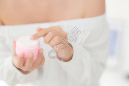 美丽与特写手亚洲女应用保湿霜或乳液护肤霜化妆品图片