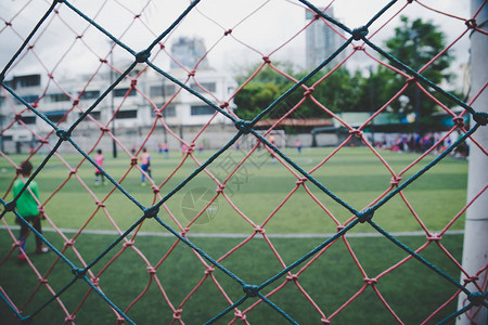 青少年足球比赛联在网后模糊的一个小足球场您的青年体育概图片