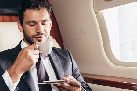 穿着西装的英俊商人在私人飞机图片