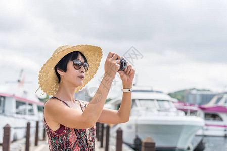 身戴帽子的亚洲旅行女人在图片