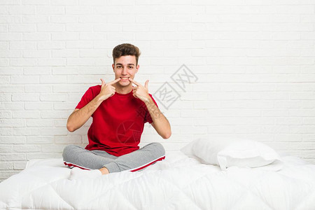 年轻的青少年学生男人在床上微笑图片