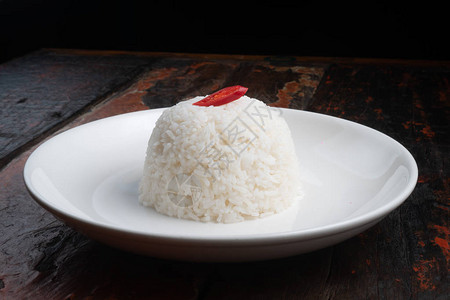 白色盘子上的茉莉花蒸米饭在生锈的木制厨背景图片
