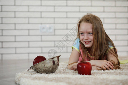 小女孩躺在地板上吃苹果图片