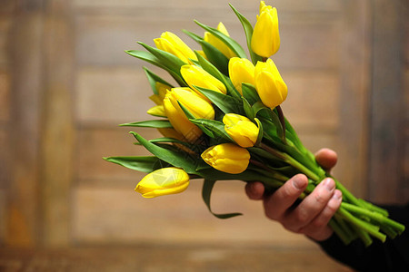 一束黄色郁金香放在地板上的花瓶里黄色郁金香花送给女人节的礼物美丽的黄色花朵在背景图片