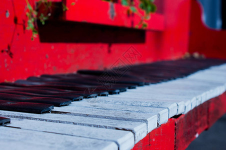街上一架红色钢琴的键带花的乐器图片