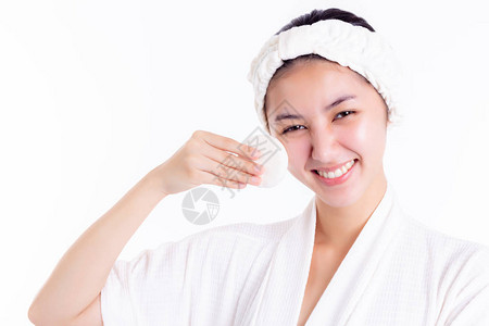 漂亮的女人通过擦拭使用化妆棉清洁乳液面部爽肤水来清洁美丽的脸庞图片