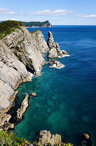 海岸附近清澈的海水中湛蓝的海水和碧绿的礁石岩石高出海面太平洋背景图片