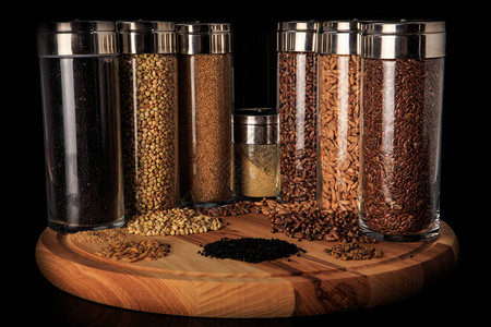 将各种亚麻小麦绿荞麦小米碎粒装在木板上的高玻璃罐中图片