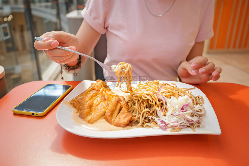 在餐厅吃炸鸡胸肉和的女人图片