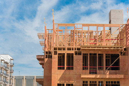 正新鸡排正在建设中的公寓大楼的木制结构新建成的建筑物德克萨斯州达拉斯附近带多层车背景