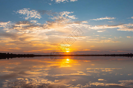 日落倒影泻湖在云层和蓝天之上的泻湖景观背景之上的美丽日落日落时有云图片
