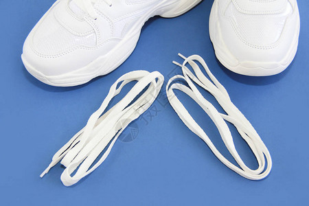 蓝色背景上的白色鞋带和运动鞋运动鞋图片