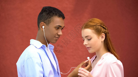 青少年分享耳机与女友分享听最喜爱的歌图片