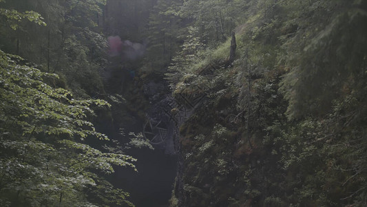 一个人站在两座山之间的峡谷中的空中图片