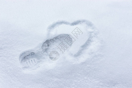 在雪地里画的心从心脏的引导和剪影的足迹冬天概念伤心图片