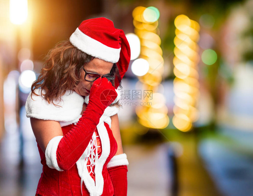 身着圣诞老人服装的中年妇女感到疲惫疲劳和头痛图片