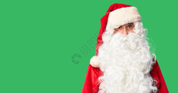 身着圣诞老人服装和胡子的中年英俊男子站立忧郁并担心痛苦愤怒和恐惧图片