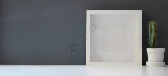 在现代工作空间的白色桌和深灰壁背景上与锅中的仙图片
