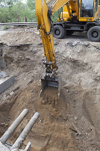 由挖掘机用挖掘机开水管的沟渠城市给排水维修管道更图片