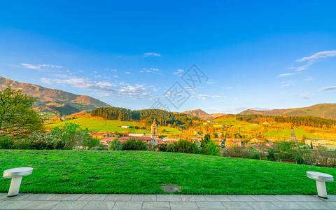 山上的绿草场山谷中村庄的风景欧洲阳光明媚的日子里图片
