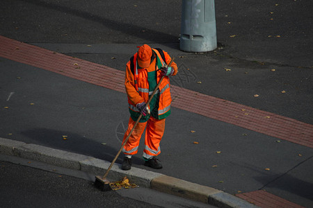 穿着橙色制服的清道夫扫街图片