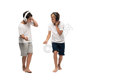 两兄弟用耳机听音乐在白人背景下背景图片