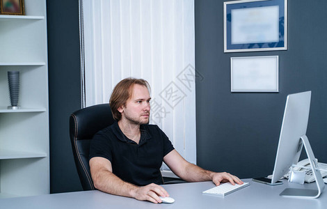 一位年轻自信的男医生坐在医务室服务台图片