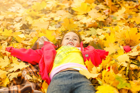 一个小孩在树叶上玩耍图片