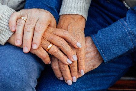 一对老夫妇的手握着结婚戒背景图片