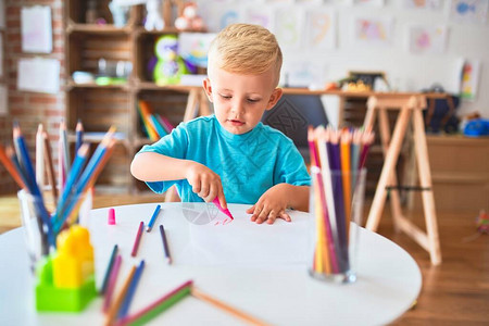 幼稚的天主教儿童在幼儿园用彩色铅笔绘画图片