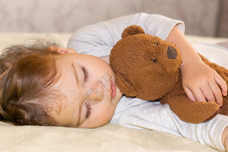小婴儿抱着一只泰迪熊睡觉图片