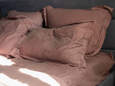 四张折叠的枕头和一张床单在床上太图片